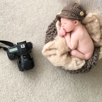 Newborn boy naked in a basket with knitted brown hat in Gainesville newborn photographer studio