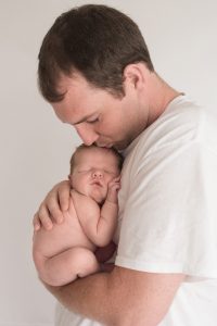 Dad cuddling brand new newborn boy