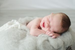 Newborn boy with big smiles on wool fluff photo