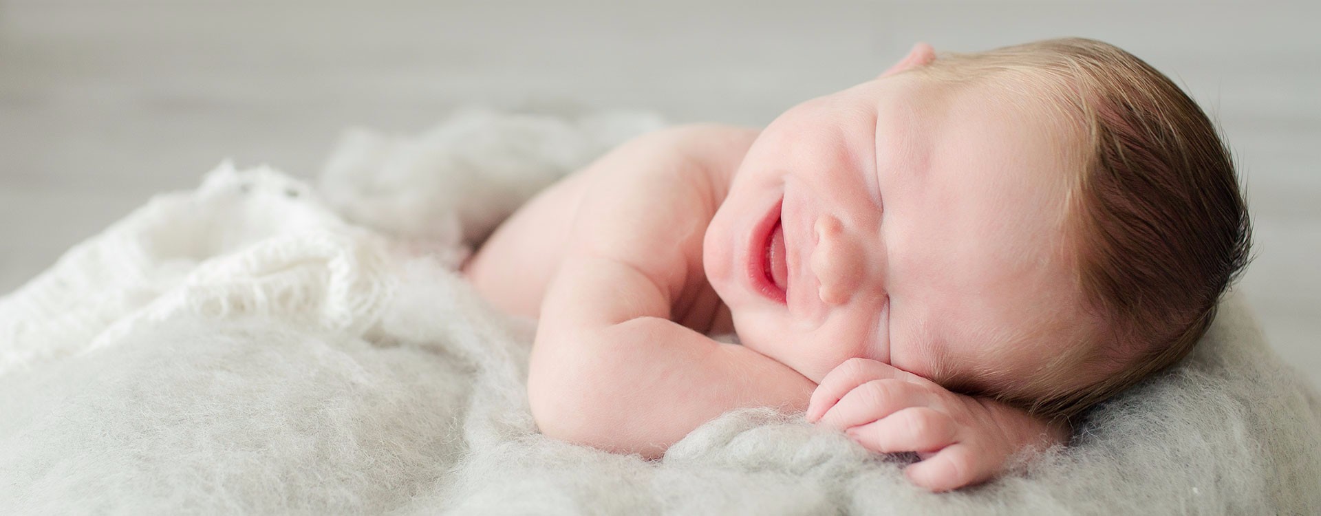 Laughing newborn eyes closed mouth wide open lots of red hair on gray fur Gainesville Florida photo