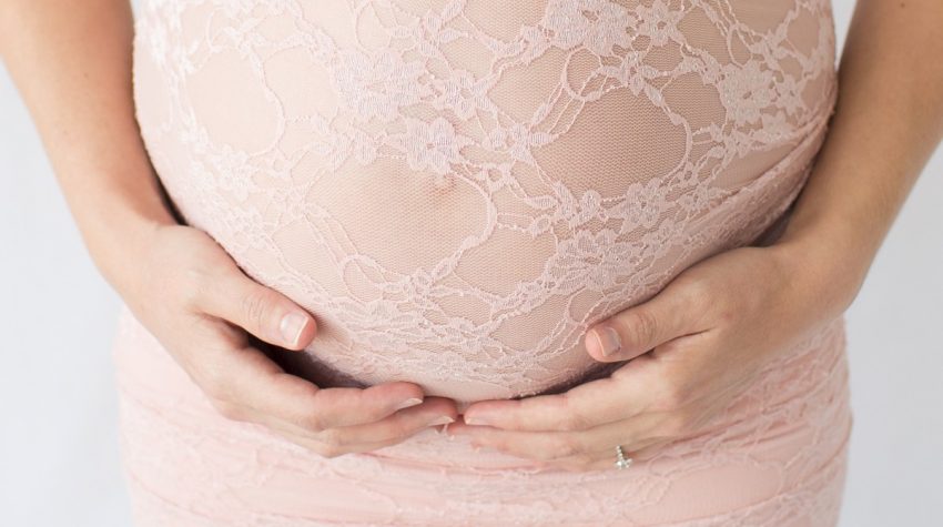 Baby bump dressed in pink lace for maternity session Gainesville Florida