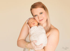 Mother cuddling newborn girl with emotion