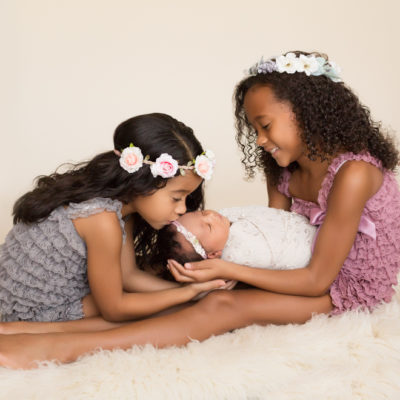 Joyful sisters loving newborn sister in Gainesville Florida