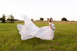 April with wind blown white maternity gown and twin girls in Gainesville Florida