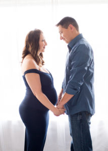 April and James back lit Maternity photos in navy gown carrying Twin girls in Gainesville Florida-3