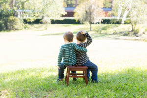 Family photo session at park with two year old twin boys shoulder to shoulder