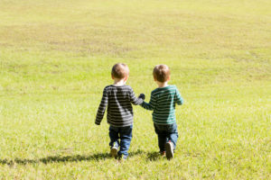 Family photo session at park with two year old twin boys running