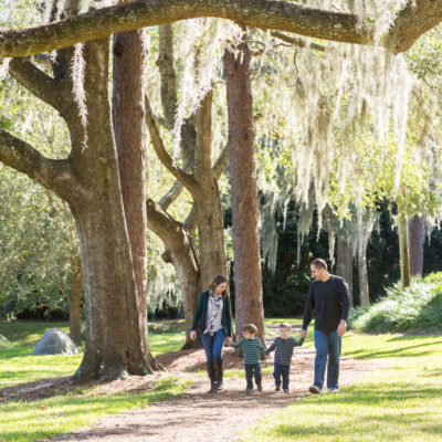 Family walking at park with two year old twin boys