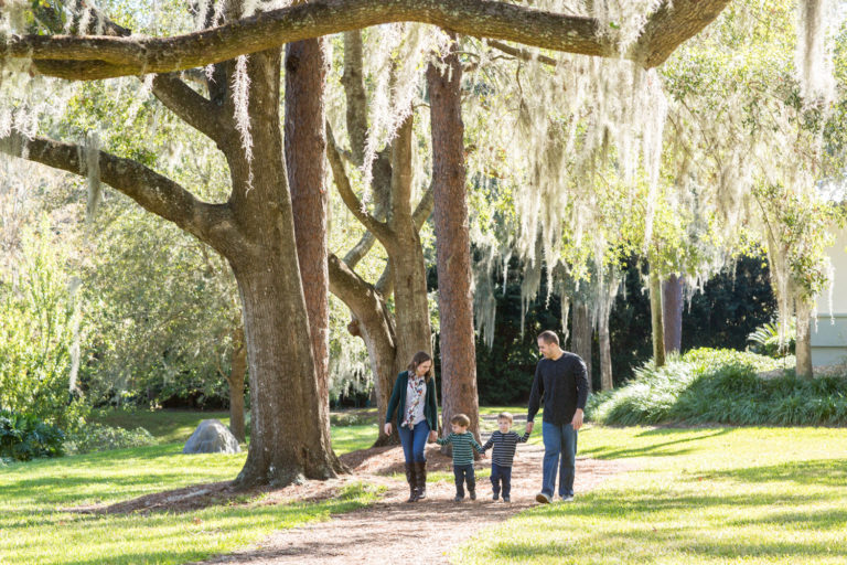 Family walking at park with two year old twin boys