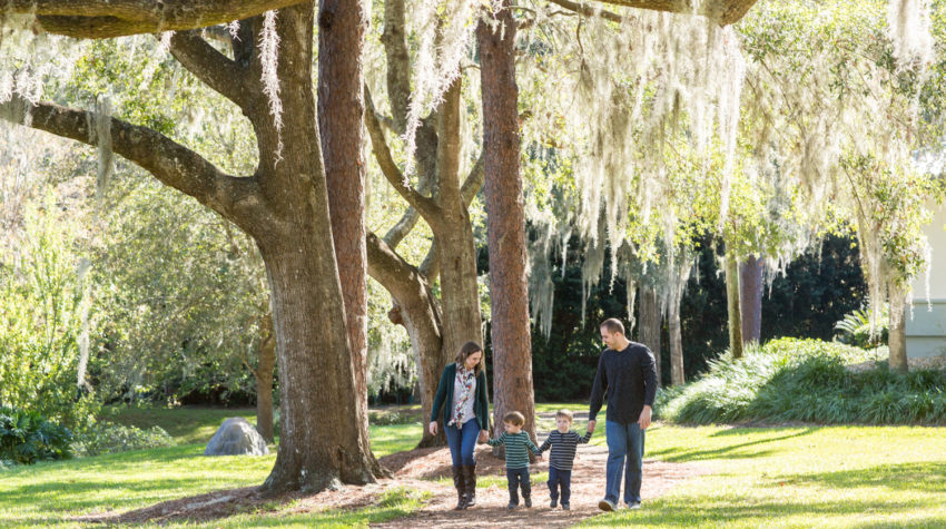 Family walking at park with two year old twin boys