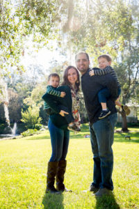 Posing piggy back with back light for family photo session at park with two year old twin boys