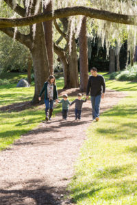 Family taking a walk at park with two year old twin boys