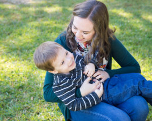 Family photo session at park with two year old twin boys tickling and laughing