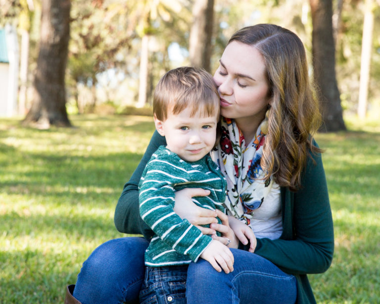 Family photo session at park with two year old twin boy shy grin