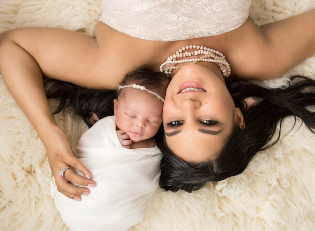 Babygirl with glamorous mom in Newborn Photosession on cream fur