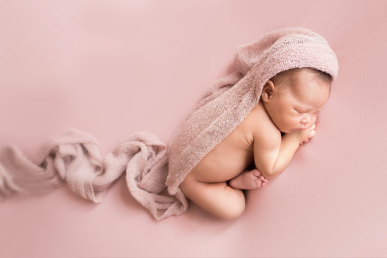 Baby girl newborn session posed on belly in Newborn Photo session on Soft Pink Baby Blanket Gainesville Florida