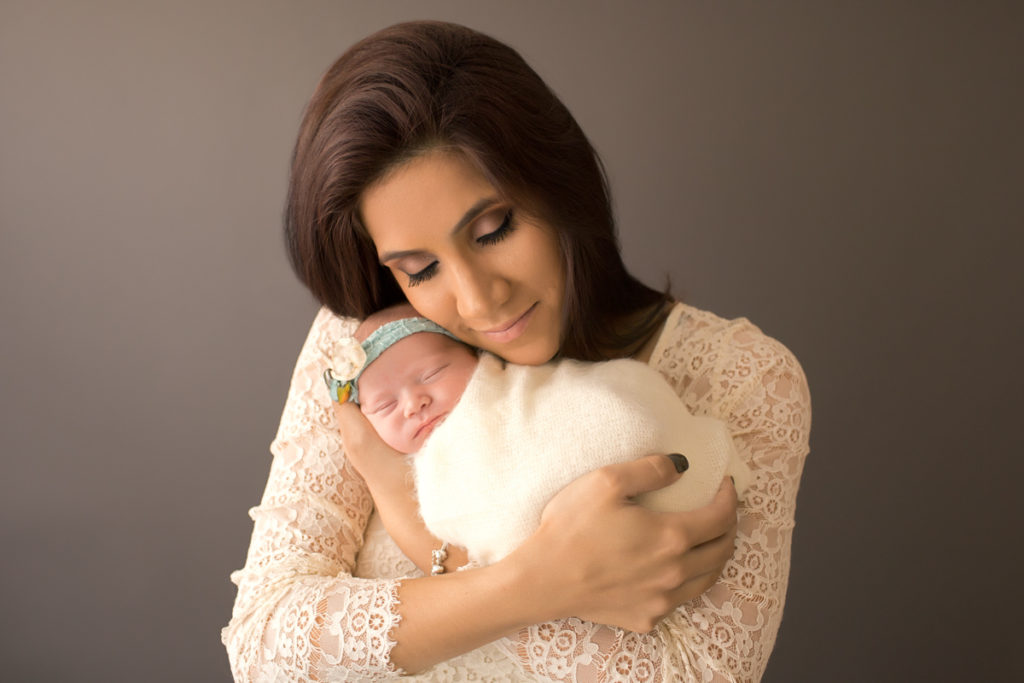 Baby girl Charleigh and Mom eyes closed in lace cudding newborn in Gainesville Florida