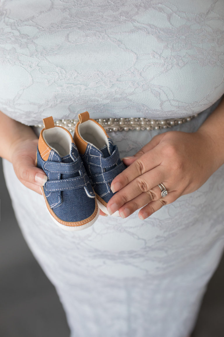 Maternity photo of Pregnant Adelis in full length Blue Lace gown and Pearls with baby booties in moms hands in Alachua Florida