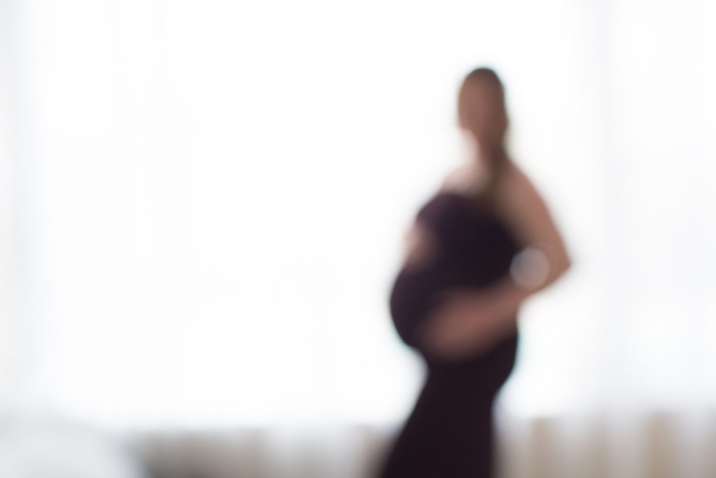 Maternity meditations of her unborn child with backlight