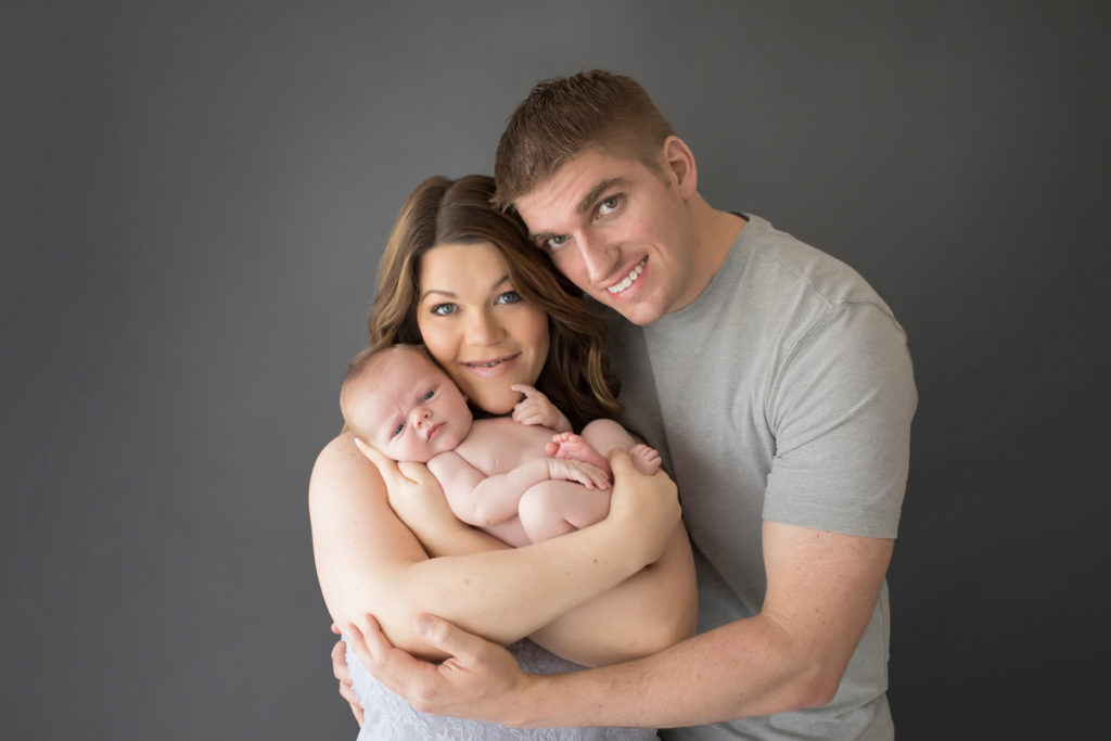 Mom and Dad cuddling naked baby newborn boy first family portrait in Gainesville Florida