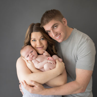 Mom and Dad Shelly and Daniel cuddling naked baby newborn boy first family portrait in Gainesville Florida