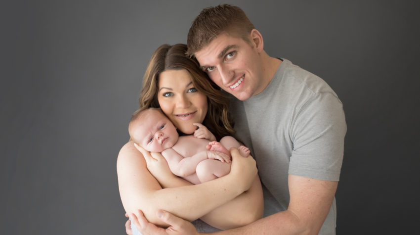 Mom and Dad Shelly and Daniel cuddling naked baby newborn boy first family portrait in Gainesville Florida