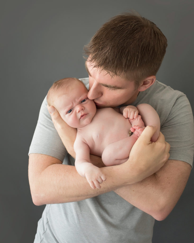 Dad cuddling naked baby newborn boy in Gainesville Florida