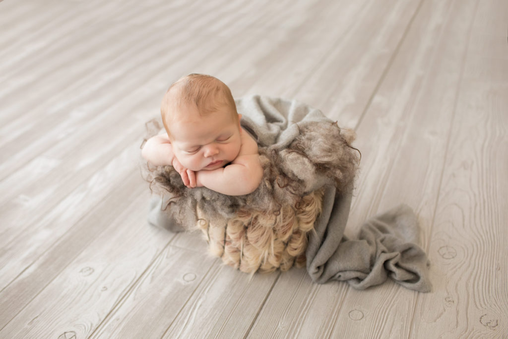 Baby newborn boy in bucket with fur in Gainesville Florida