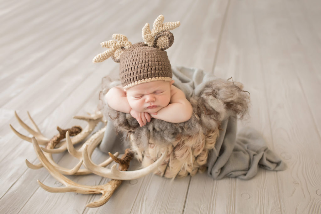 Baby newborn boy in bucket with fur antlers and bonnet in Gainesville Florida