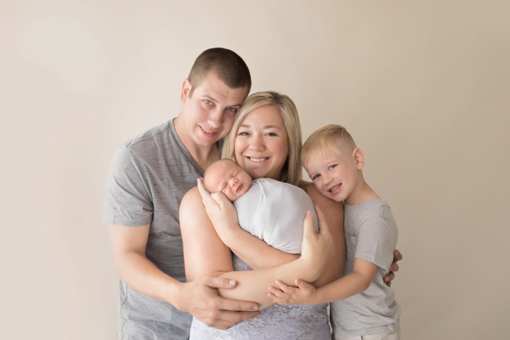 Family photo mom dad toddler and newborn baby grey and neutral colors