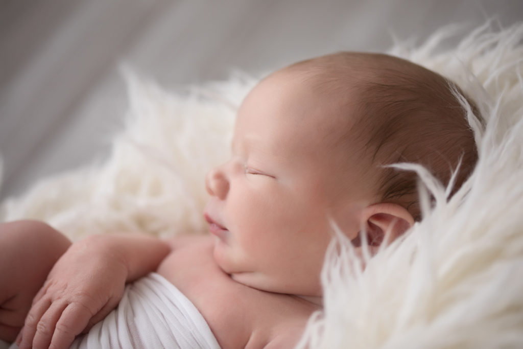 Naked baby newborn boy Chase close up profile with white fluff and wrap in Gainesville Florida