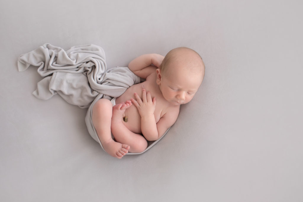 Naked baby newborn boy Chase photographed from above on grey blanket in Gainesville Florida