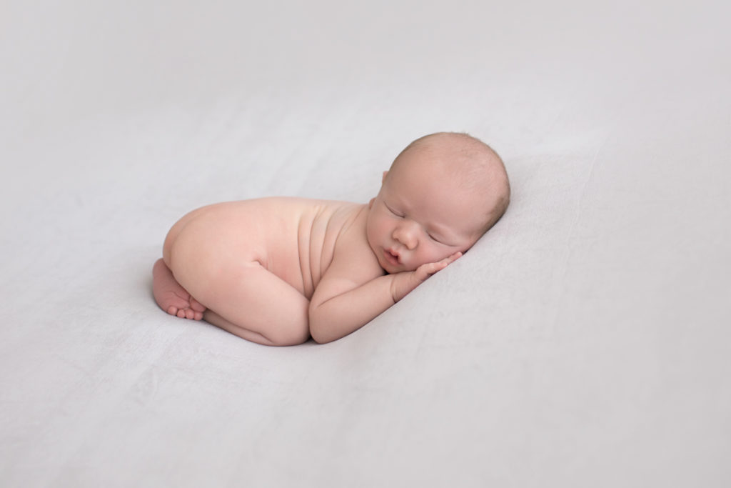 Naked baby newborn boy Chase with his bottom up on grey blanket in Gainesville Florida