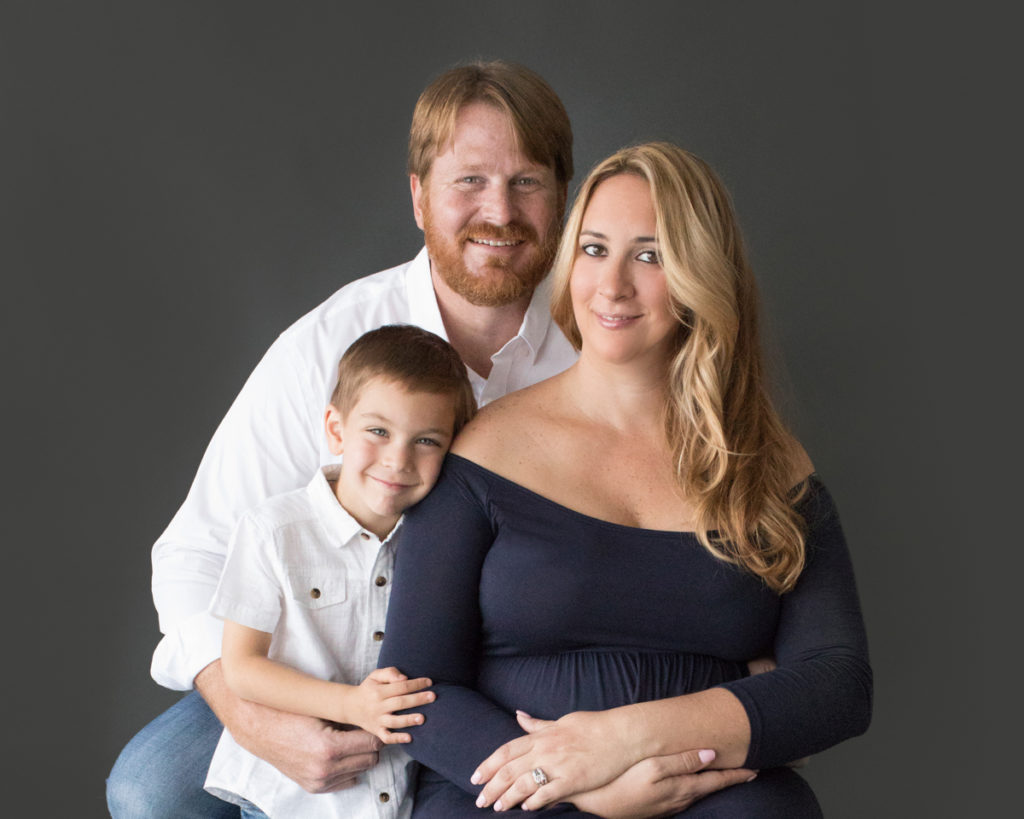 Dad and pregnant mom and big brother pose for family photos before little sister is born