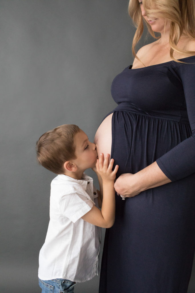 Proud big brother kisses moms pregnant belly and loves his unborn baby sister