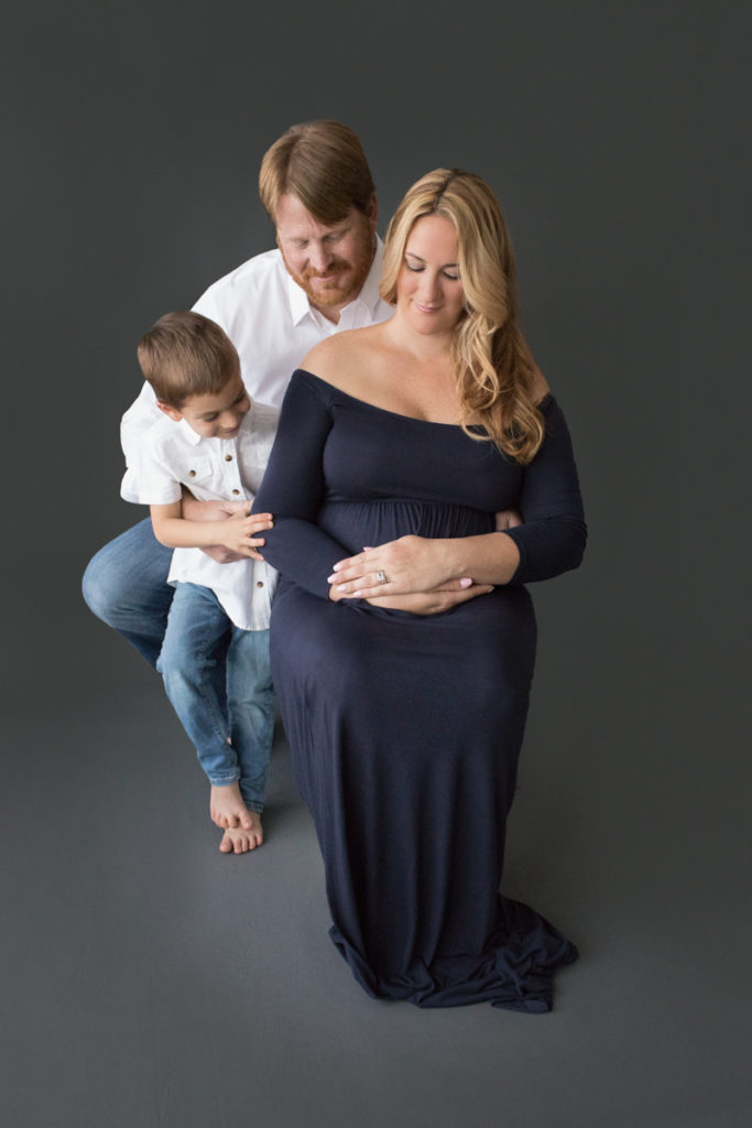 Dad pregnant mom and big brother pose for family photos before little sister is born