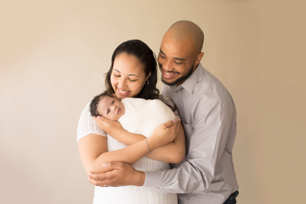 New Mom and Dad cuddling Newborn Girl Ayana in neutral shades of white grey and beige