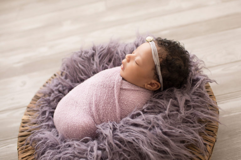 Newborn Girl Ayana profile photo wrapped in purple shades in purple fur and basket pictures Gainesville Florida