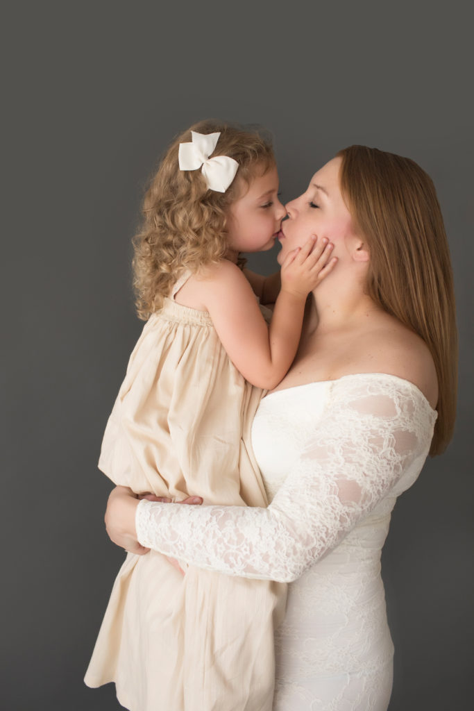 Morgan and Sydney mother dauther kiss dressed in coordinating gowns for maternity photos