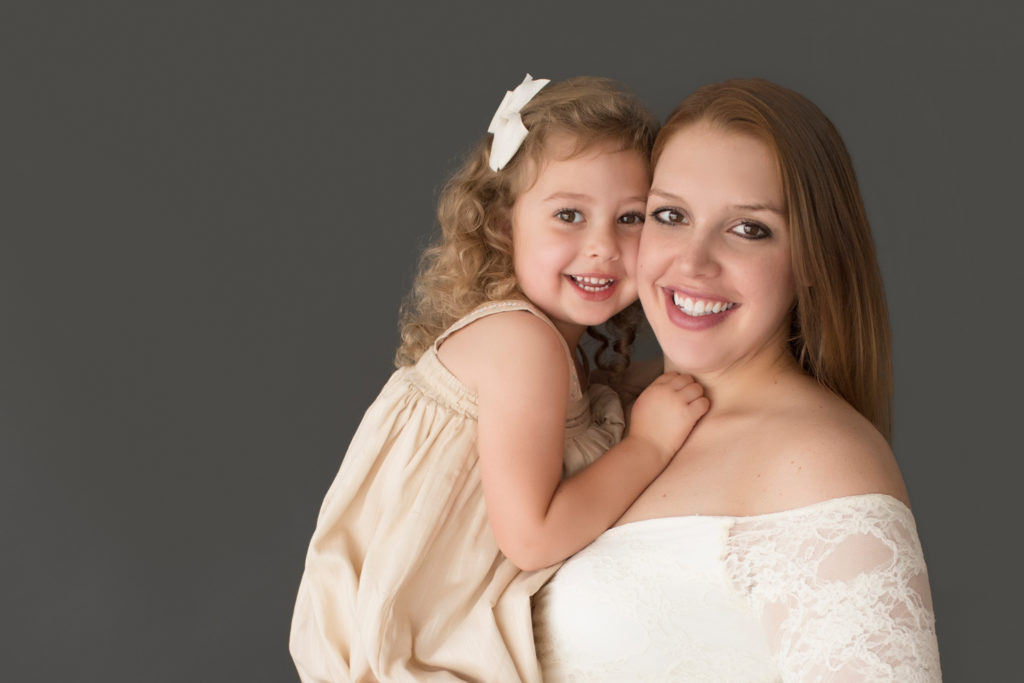 Morgan and daughter Sydney close up beautiful faces dressed in coordinating gowns for maternity photos