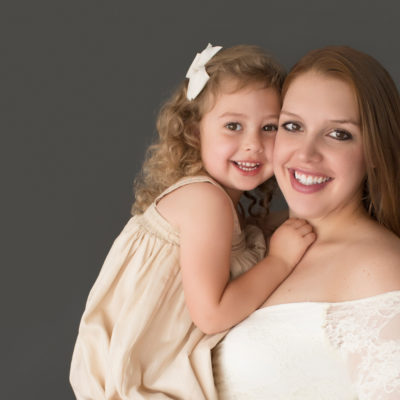 Morgan and daughter Sydney close up beautiful faces dressed in coordinating gowns for maternity photos in Gainesville FLorida