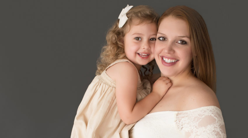 Morgan and daughter Sydney close up beautiful faces dressed in coordinating gowns for maternity photos in Gainesville FLorida