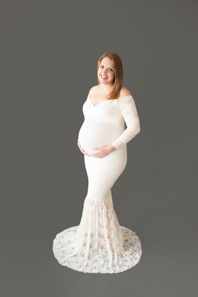 Morgan dressed in lace mermaid maternity gown formal standing pose big smile
