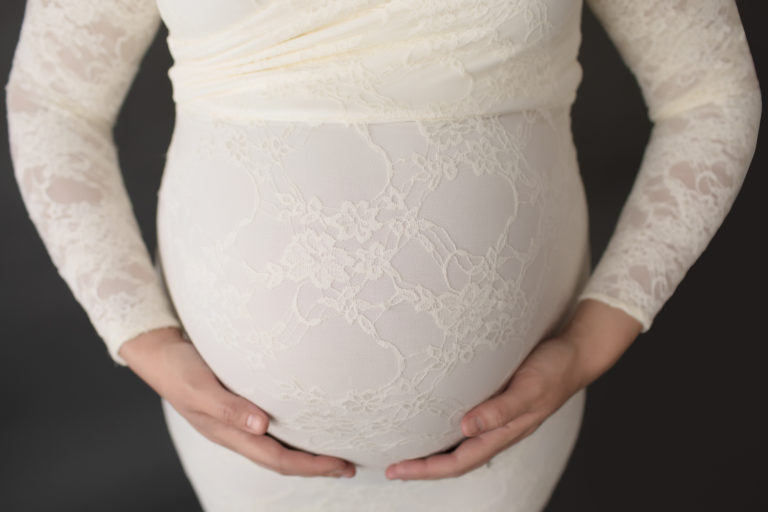 Morgan dressed in lace mermaid maternity gown close up belly with moms hands in Gainesville FLorida