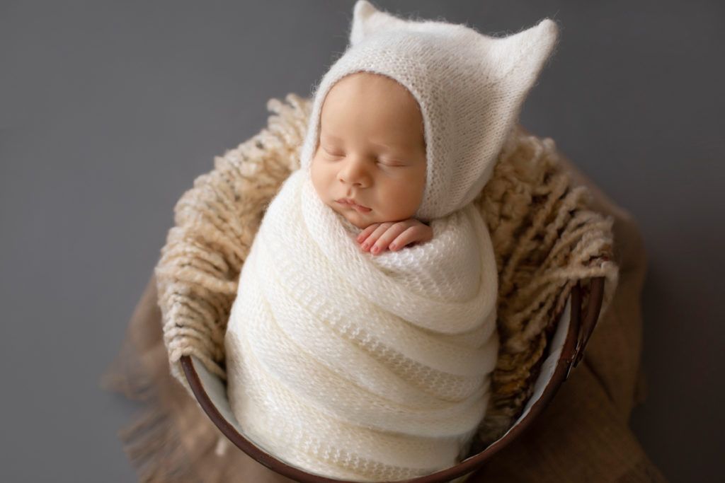 Newborn Baby Rowan wrapped in white knit potato sack posed in bucket Gainesvile Florida Photos