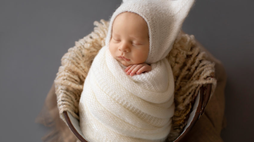 Newborn Photos Baby Rowan wrapped in white knit potato sack posed in bucket Gainesvile Florida Photos