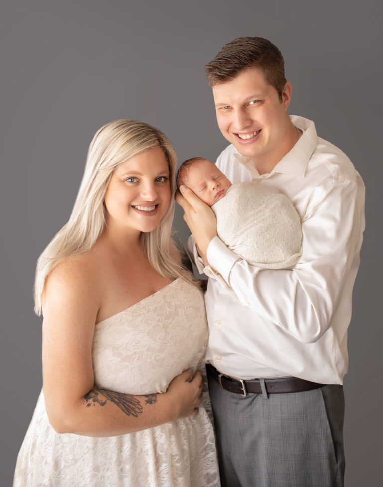 Mom and dad looking up smiling cuddling newborn baby Rowan Gainesvile Florida Newborn Photos