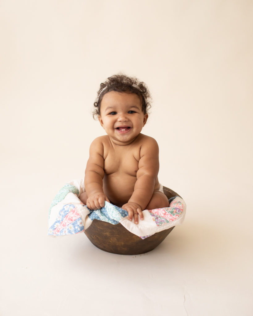 Baby 6 months old laughing sitting in wood bowl with quilt in Gainesville FL