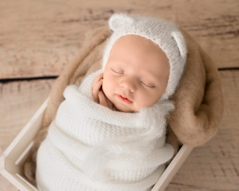 Gainesville Newborn Boy Gavin potato sack white knit wrap and bear hat on beige blanket in white crate Andrea Sollenberger Photography