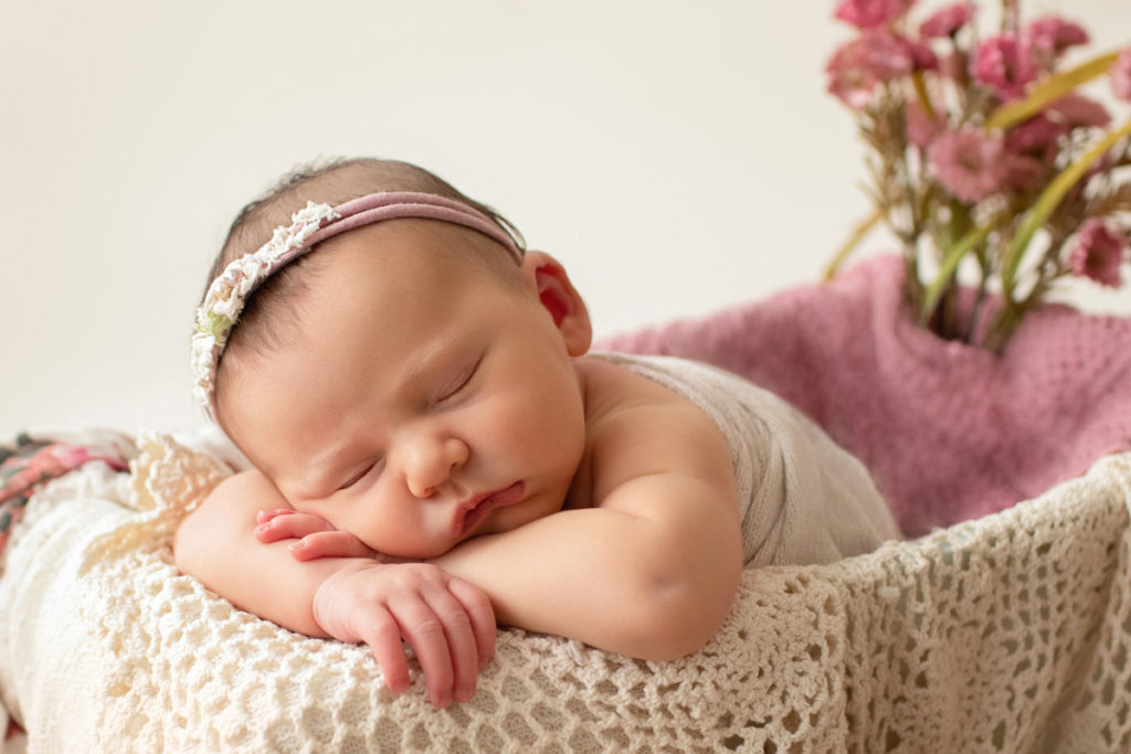 Hensley newborn photos posed sleeping on her arms in drawer draped with ivory lace pink blanket and head tie rose floral accents Gainesville Florida Newborn Photography